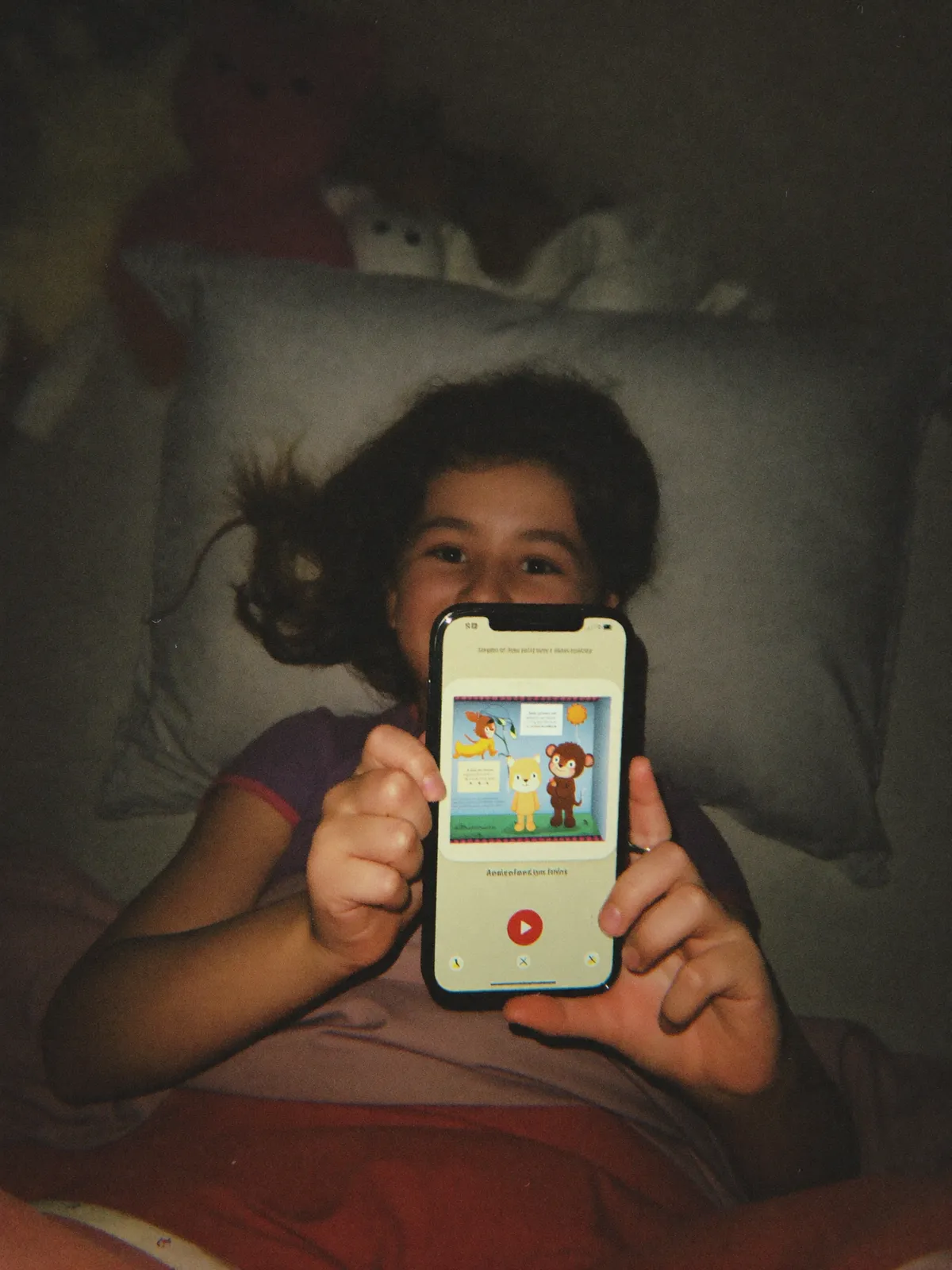 A child asleep, a tablet glowing softly on the nightstand